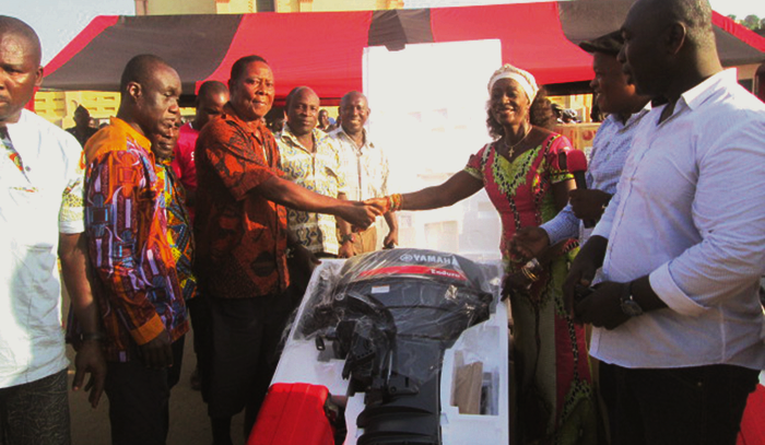  Ms Sherry Ayittey, Fisheries Minister (3rd right) shaking hands with Supi Kobina Gyan after presenting an outboard motor to him